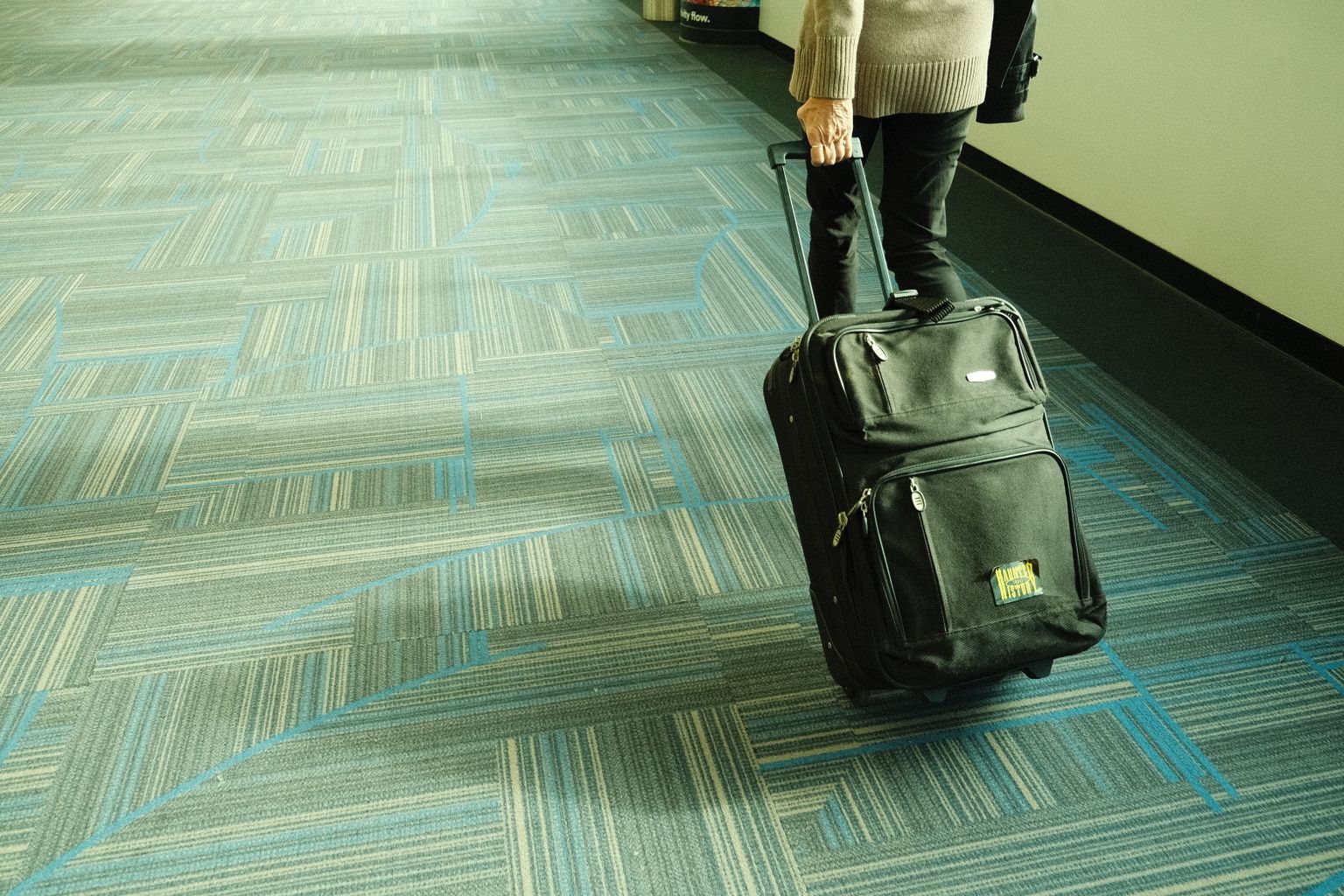 Traveller with carry-on luggage walking through the airport
