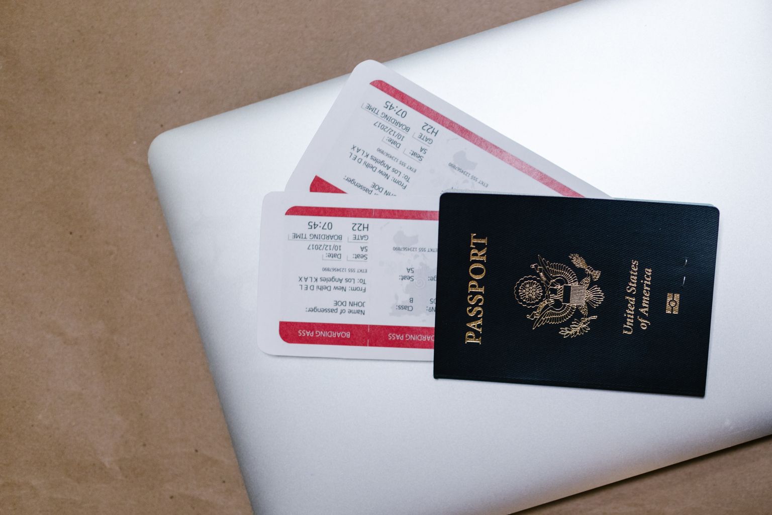 Booking last minute flights on a laptop with passport and boarding passes