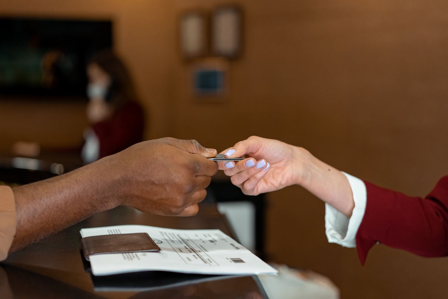 Guest handing a credit card to a hotel receptionist for the security deposit at check-in