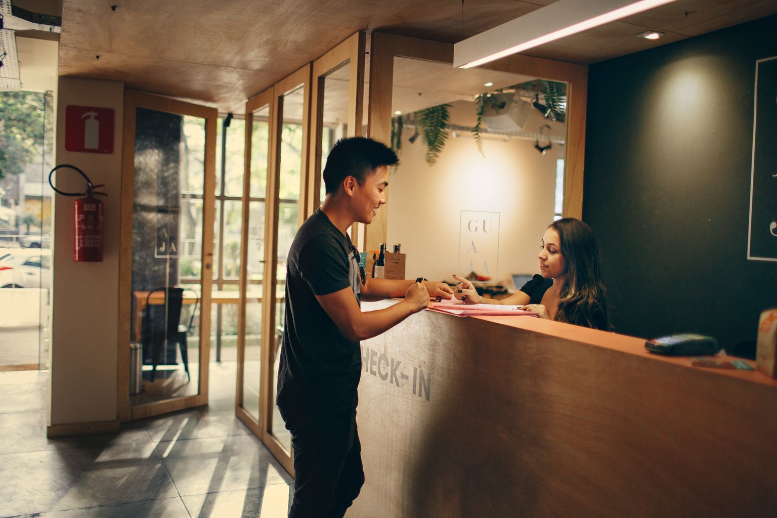Guest checking in at a hotel reception desk with a Hotels.com booking
